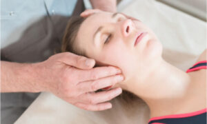 A woman having her physical therapy to address TMJ disorder.